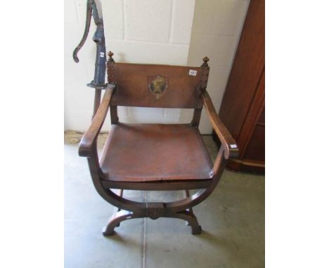 An oak and leather hall chair with coat of arms in back.