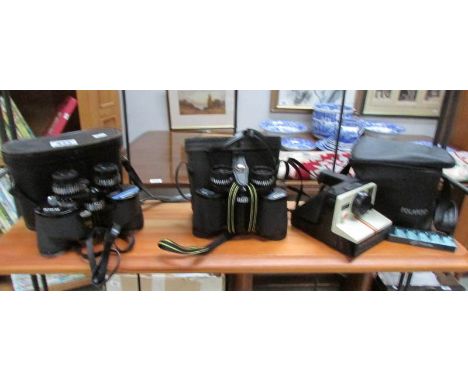 2 cased binoculars and a Polaroid camera.