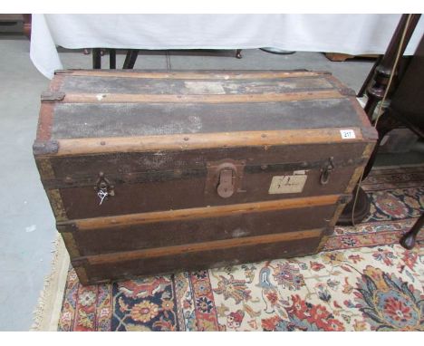 A dome top trunk with tray and featuring luggage labels including LMS railway.