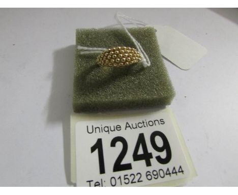 A textured 9ct gold ring, size K.