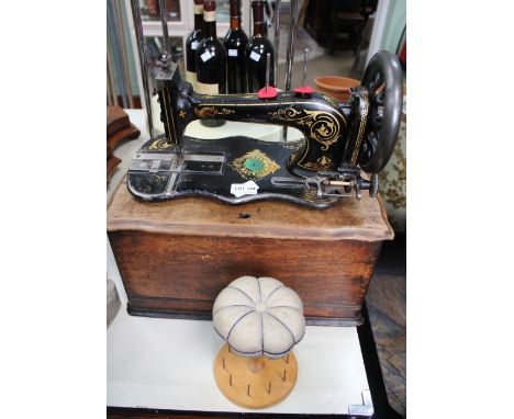A Shaker Workshops bobbin stand and pin cushion, together with a manual Jones Family sewing machine, with remains of box