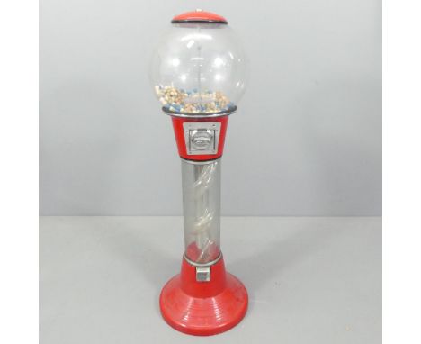 A vintage coin-in-slot gumball dispensing machine. Height 125cm.No key. 