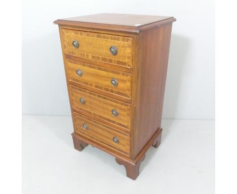 A small reproduction crossbanded mahogany chest of four drawers on bracket feet. 43x75x36cm. 