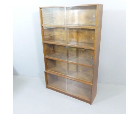 A mid-century oak five shelf sectional stacking Minty style bookcase with sliding glazed doors, by Phoenix Gallery, London. W