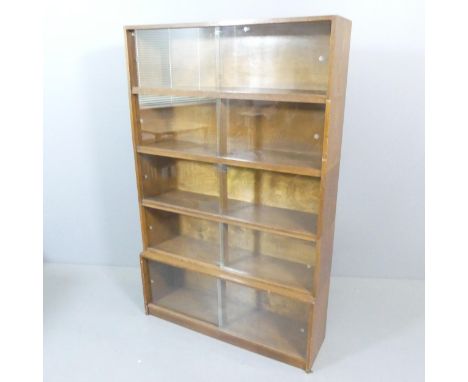 A mid-century oak five shelf sectional stacking Minty style bookcase with sliding glazed doors, by Phoenix Gallery, London. W