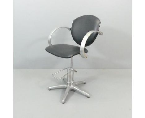 A vintage leather upholstered barber's swivel chair on metal base, with rise and fall mechanism. 