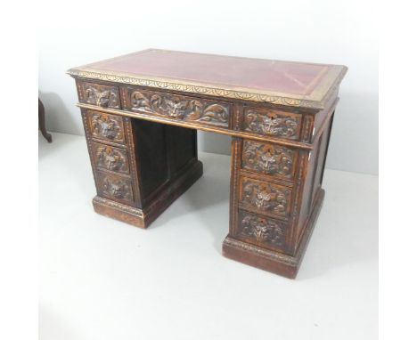 A Victorian carved oak twin pedestal writing desk, with tool and embossed red leather skiver and nine drawers. Overall 107x75