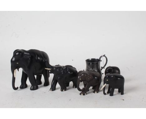 Five ebony elephants, one with trunk raised, silver plated christening mug initialled PEE (6)