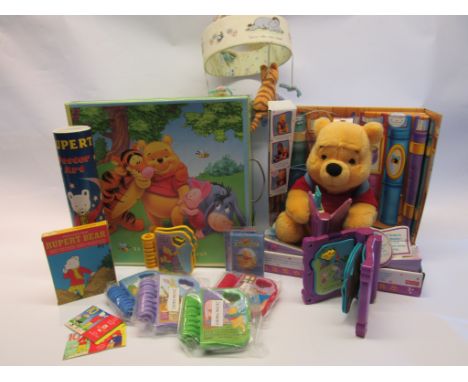 A Disney Winnie The Pooh storage box containing Fisher Price 'Read With Pooh' mobile and cassettes and Rupert Bear cassettes,