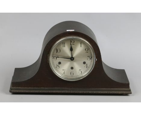 An oak dome top mantle clock with silvered dial, Westminster chiming.  Condition Report. To be used as a guide only. No pendu