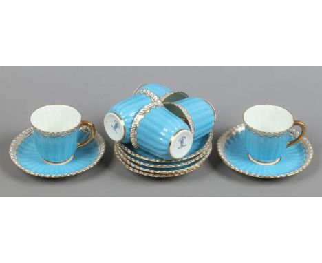 Six Royal Crown Derby coffee cups and saucers with fluted moulding, blue ground and with gilt edging.