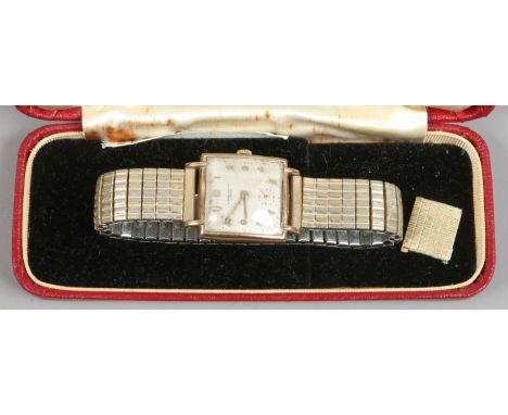 A gentlemans J. W. Benson manual 9ct gold watch on plated bracelet strap. With square silvered dial, applied Arabic numeral m