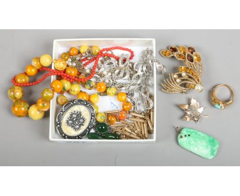 A small box of costume jewellery including a jade effect negligee pendant on chain etc.  