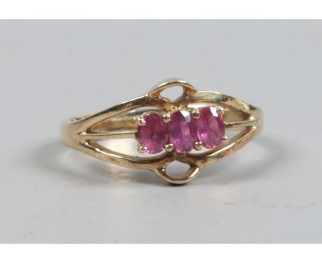 A 14ct gold three stone ruby ring on split shank, size N.