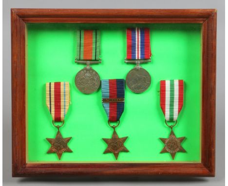 A framed display of 5 World War II medals, The Defence medal, The 1939-1045 Star with 1st Army clasp, African Star, Italy Sta