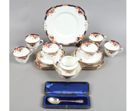 A Salon china six place tea service decorated in the sterling design along with a cased silver christening spoon, assayed She