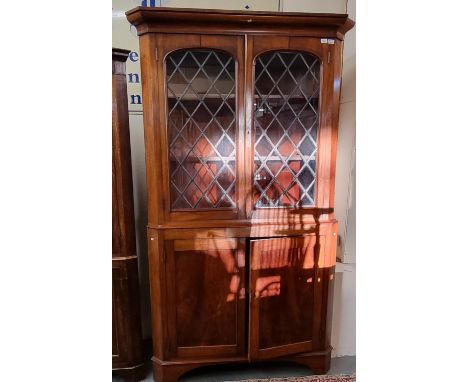 19th century mahogany two stage corner cabinet, the moulded cornice above two lead glazed doors, standing on bracket feet.  (