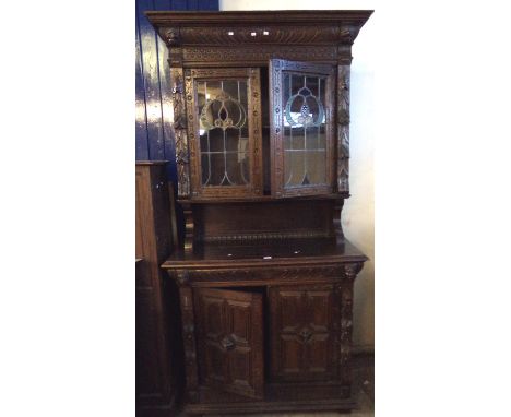 Late 19th century oak Flemish design ornately carved two stage stained and leaded glass cabinet backed bookcase. (B.P. 21% + 