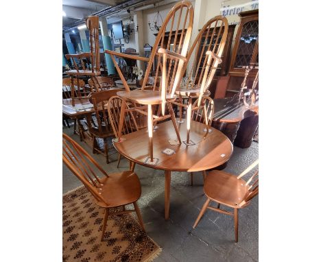 Mid century elm Ercol drop leaf kitchen table together with a set of six elm and beech hoop and spindle back chairs, two carv