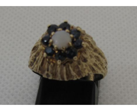 A sapphire and opal ring set in 9ct gold bark effect mount.  Ring size L.  Approx weight 4.7 grams.(B.P. 21% + VAT) 