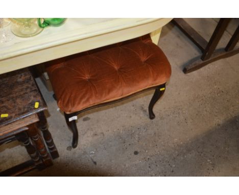 An upholstered button down dressing stool