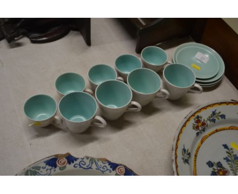 A quantity of Poole twin tone tea and coffee cups; with some saucers