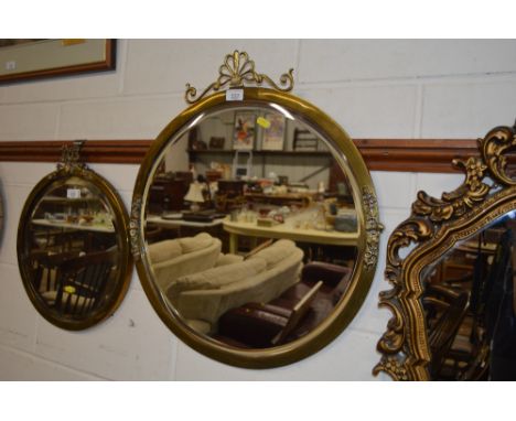 A circular brass and bevel edged wall mirror