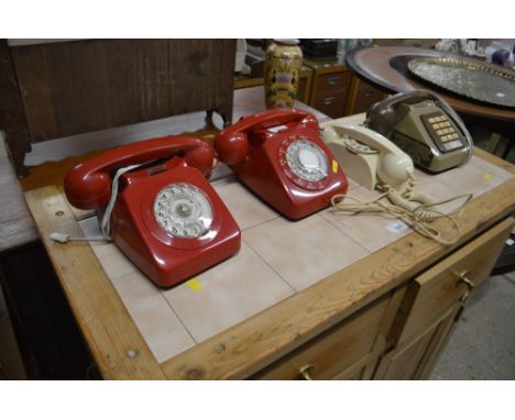 Three various rotary dial telephones; and a push button telephone 