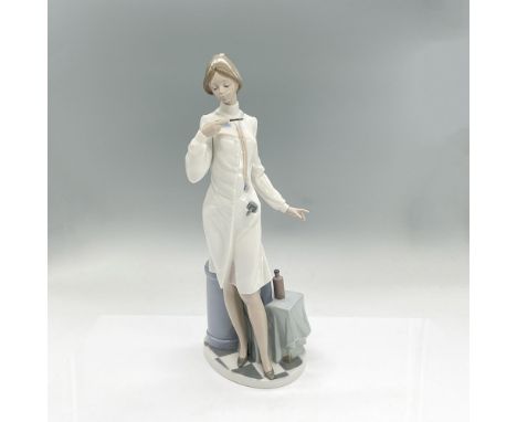 Glazed porcelain figure of a lady doctor in a white coat with a stethoscope around her neck, holding a thermometer. Lladro ba