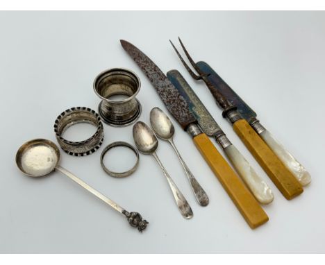 Collection of silver items including spoons, a cream ladle, napkin rings and some cutlery with silver mounts.
