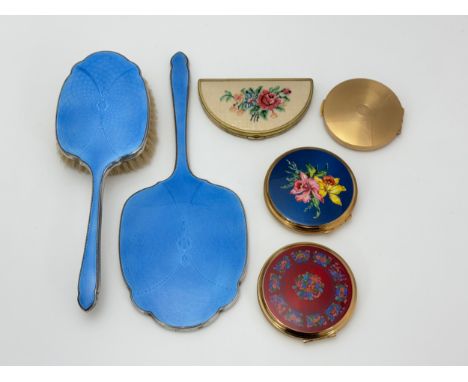 Four compacts including two by Stratton, and a white metal guilloche enamel dressing mirror and brush.