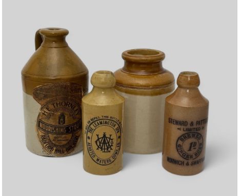 Four stoneware items. A flagon with printed paper label attached for H.E. Thornley of Leamington nourishing stout bottled at 