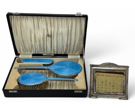 A silver mounted desk calendar with hallmarks for Charles S Green &amp; Co Ltd, Birmingham 1915. 14cm wide, 13.5cm high. Toge