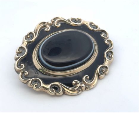 A Victorian banded sardonyx and enamel mourning brooch, in yellow metal tested as 10ct gold. Some scratches and wear to the e