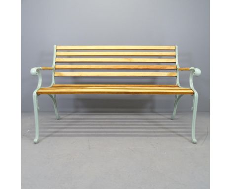 A teak slatted garden bench with cast iron ends. 136x83x64cm 