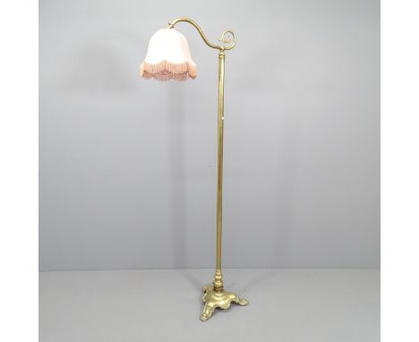 A Brass standard lamp in the manner of Christopher Wray, on tripod base. Height 170cm. 