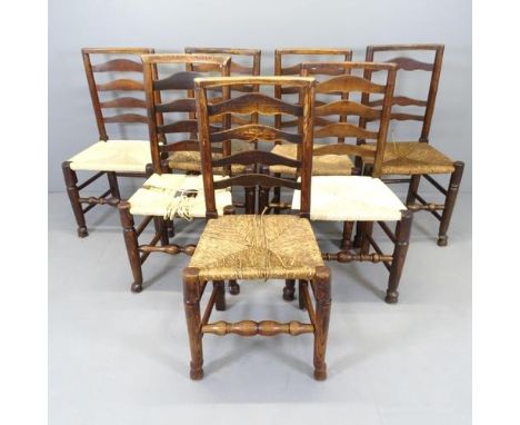 A matched set of seven oak and elm rush seated ladder back dining chairs.One rush seat A/F, four others needing varying level