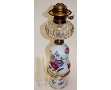 An early 20th century continental porcelain oil lamp with glass reservoir