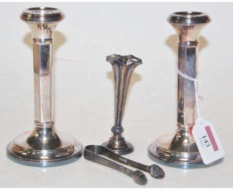 A pair of early 20th century silver dwarf candlesticks  together with a small silver spill vase and pair of sugar bows Condit