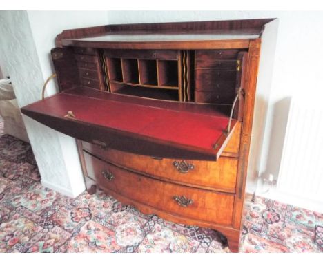 A bow fronted mahogany bureau with inlaid decoration, having two faux drawers opening to reveal a pigeon-hole fitted interior