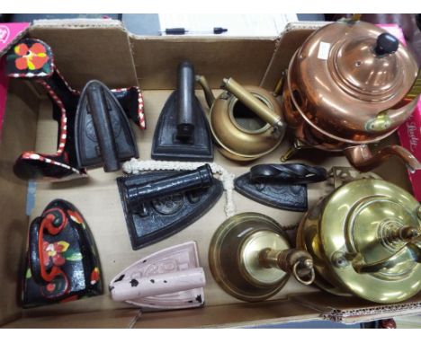 A quantity of vintage brass and copper ware to include kettles, a bell and similar,  six irons and a boot scraper. Estimate £
