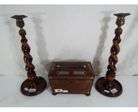 A wooden tea caddy with inlaid decoration and caddy spoon and a pair of wooden barley twist candlesticks approximately 36 cm 