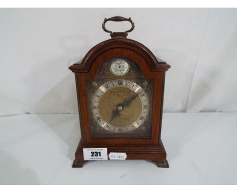 A wood cased mantel clock, Roman numerals to the dial marked 'Garrard & Co Ltd, an Elliott clock'