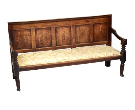 A 19th century oak settle with panelled back raised on tapering column supports, width 189cm.Additional InformationHeavy wear