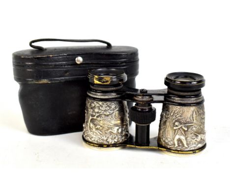 A cased pair of lacquered brass opera glasses with white metal repoussé decoration depicting a hunting scene.