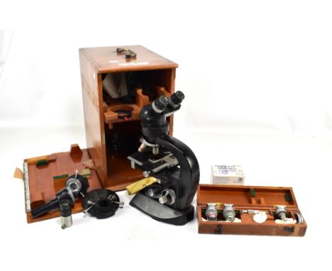 A cased Cooke binocular microscope with various accessories, lenses, etc.