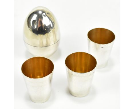 A Continental white metal tot cups and egg shaped holder, stamped 'Silver 1000', approx 3.2ozt/101g.