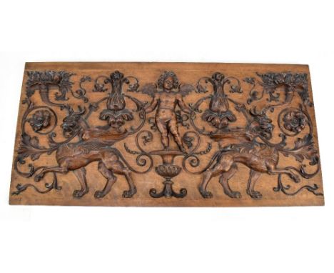 An Italian carved walnut panel featuring Cupid flanked by griffins amongst foliate scrolls, purportedly from a 17th century F