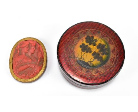 An early 19th century lacquered circular snuff box with painted foliate and gilt detail on metallic red coloured body, diamet