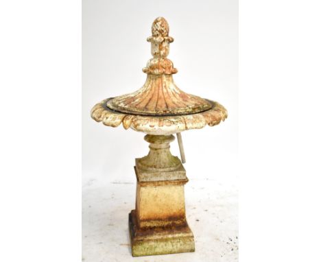 A 19th century cream painted cast iron urn with water fountain fixture, the cover with pine cone finial, on socle base to squ